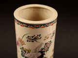 a white vase with a bird and flowers on it