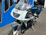 une moto garée devant un immeuble dont le mur est recouvert de graffitis