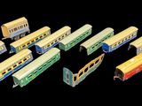 several toy trains are lined up on a black surface