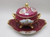 a red and gold bowl and saucer on a saucer