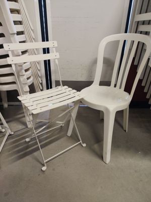 plusieurs chaises en plastique blanc et une chaise en plastique blanc dans une pièce
