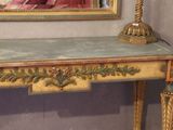 a small table with a lamp on it in front of a mirror