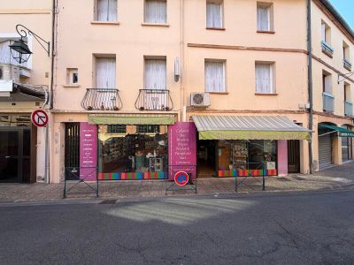 un immeuble qui comporte de nombreuses fenêtres et sur lequel est accrochée une enseigne sur le côté