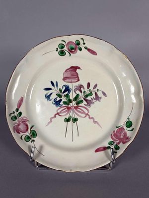 une assiette blanche ornée d'un motif rose et vert
