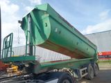 a large green truck with a large trailer on the back