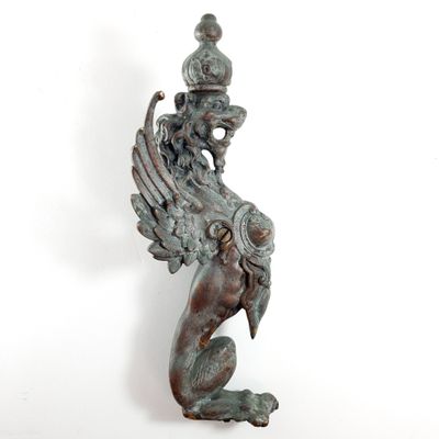 bronze statue of a winged bird with a crown on its head
