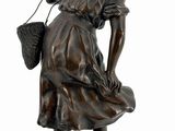 bronze statue of a woman with a basket on her head