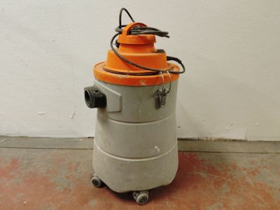 un aspirateur orange et gris posé par terre