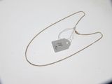 un collier en argent muni d'une médaille, posé sur une table