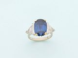 a blue sapphire and diamond ring on a white surface