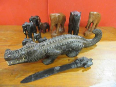 a statue of an alligator with a knife and other figurines on a table