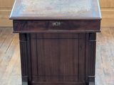 a small wooden table with a marble top on a hard wood floor