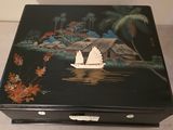 une boîte noire sur laquelle est peinte une barque sur l'eau