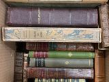 many books in a box that are stacked on top of each other