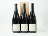 trois bouteilles de vin sont posées devant une caisse en bois