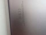 the back of a silver tablet computer sitting on top of a table