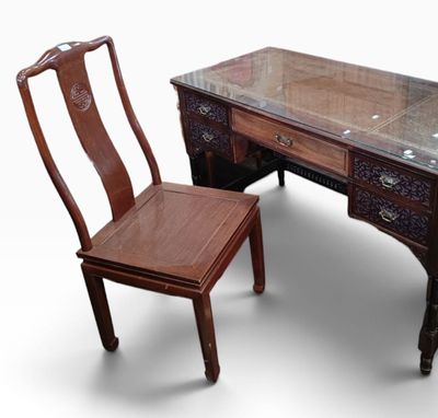 a wooden desk with a glass top and a chair