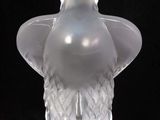 a clear glass vase with a bird on it