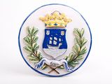 a blue and white plate with a coat of arms and a crown on it