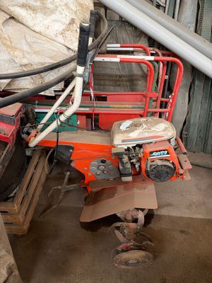 un homme debout à côté d'un tas de vieilleries dans un garage