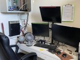 a desk with two computer monitors and a chair