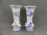 two vases that have been decorated with blue and yellow designs
