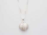 a white gold and diamond ball pendant on a silver chain