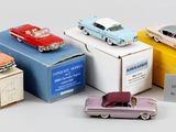 cinq petites voitures posées sur des cartons, sur une table