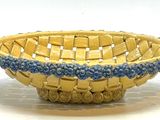 un petit panier jaune orné de perles bleues