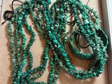 green necklaces and bracelets in a box on a table