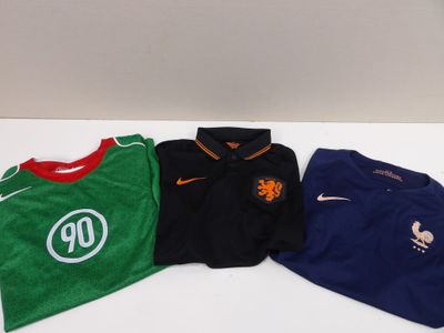 three soccer shirts are sitting on a table next to each other