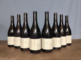 six bottles of wine are lined up in a row on a table