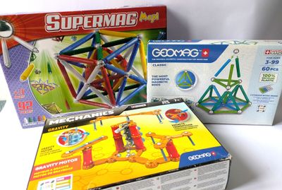 deux boîtes de jouets et une boîte d'aimants posées sur une table