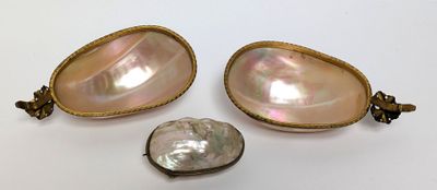 a close up of three pieces of jewelry on a white surface