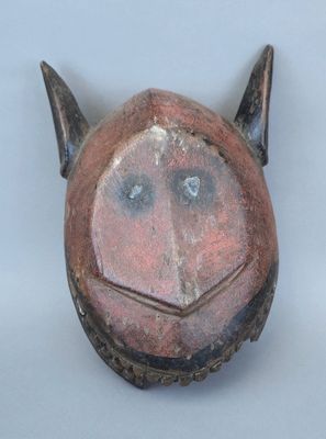 un masque marron muni de cornes sur un fond blanc