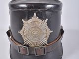 un petit chapeau noir orné d'un insigne doré