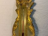 une horloge dorée avec un cadran rouge