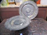 une assiette en argent posée sur une table, à côté d'une bouteille d'eau