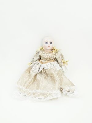 une image représentant une poupée aux cheveux blonds et vêtue d'une robe blanche