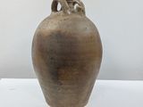 a large brown vase sitting on a white table