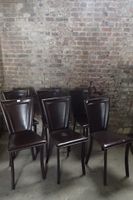Ensemble de six chaises entièrement gainées de cuir brun.