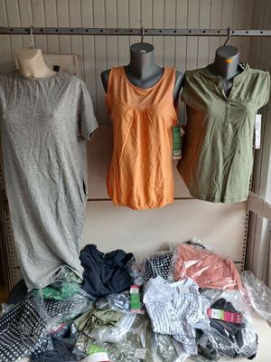 three mannequins in a closet with clothes on display