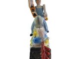 figurine of a man riding a skateboard on top of a statue