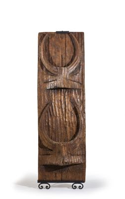 une vieille porte en bois sur laquelle est sculpté un visage