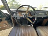 a steering wheel and dashboard of a car in a parking lot