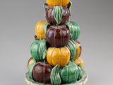 a ceramic sculpture of pumpkins stacked on top of each other