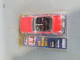 a red toy car in a package on a table