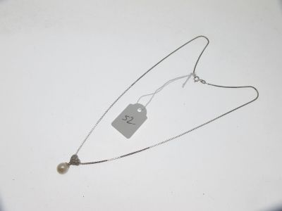 collier en argent avec une pendentif et une perle sur une chaîne