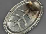 un vieux plat en argent orné d'un motif de feuilles