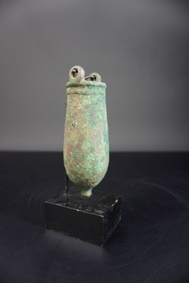 un gros plan d'un vase vert posé sur une surface noire
